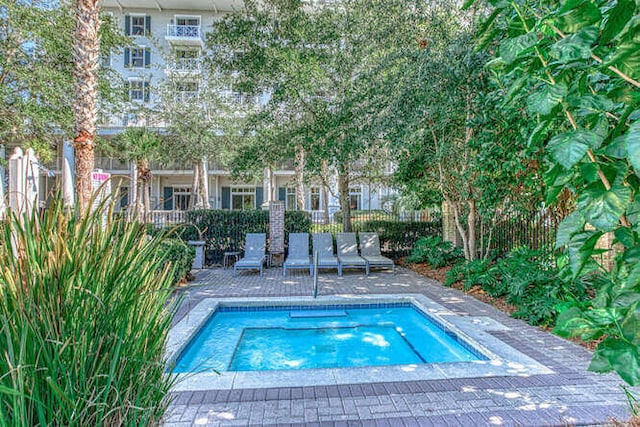 view of pool with a patio and an in ground hot tub