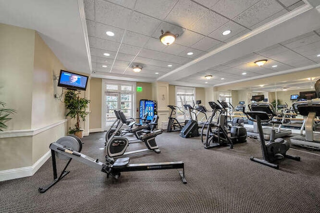 gym with a paneled ceiling and ornamental molding