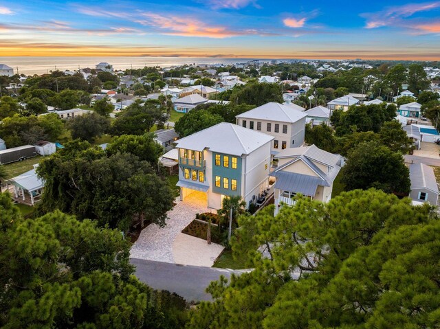 aerial view at dusk featuring a water view