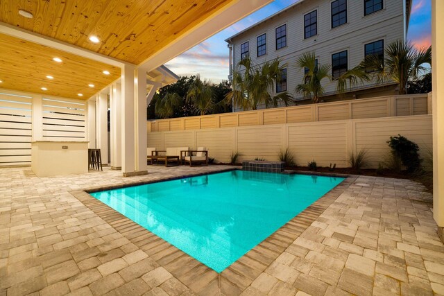 pool at dusk with a patio