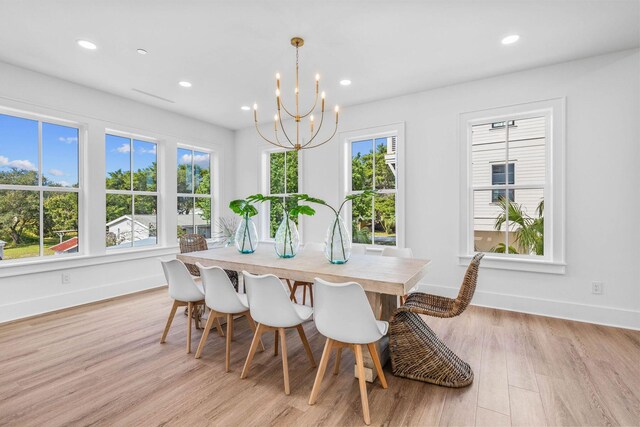 dining space featuring light hardwood / wood-style floors and an inviting chandelier