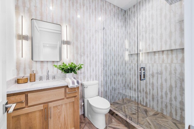 bathroom featuring tile walls, parquet flooring, walk in shower, vanity, and toilet