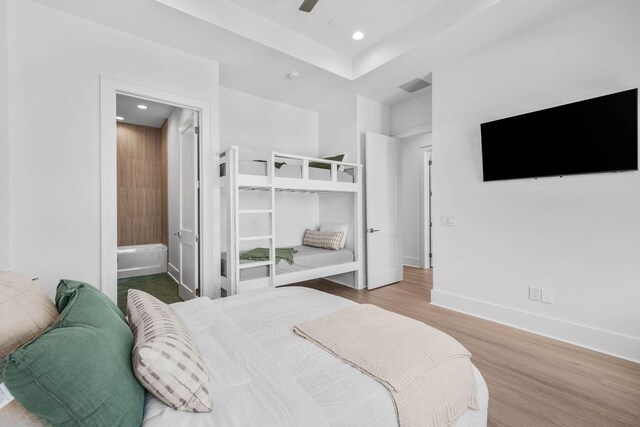 bedroom with ceiling fan, light hardwood / wood-style flooring, and ensuite bath