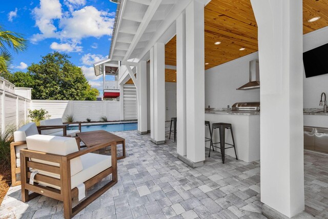 view of patio / terrace with grilling area, a wet bar, and a fenced in pool