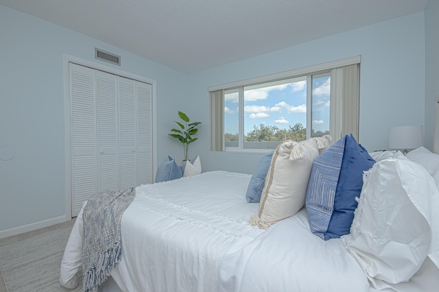 carpeted bedroom featuring visible vents, baseboards, and a closet