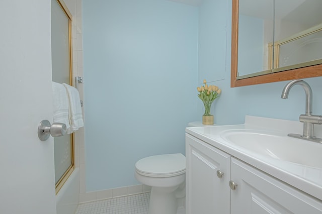 bathroom featuring vanity, toilet, baseboards, and tile patterned flooring