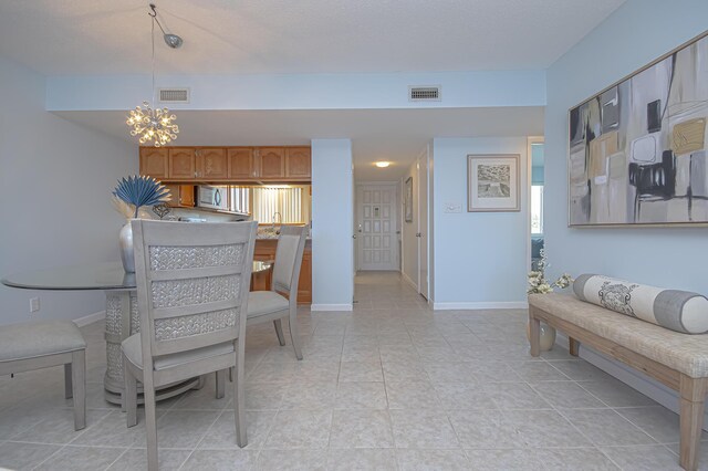 dining area with a notable chandelier, visible vents, baseboards, and light tile patterned floors