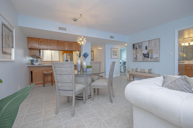 dining area with visible vents, a textured ceiling, light tile patterned flooring, baseboards, and a chandelier