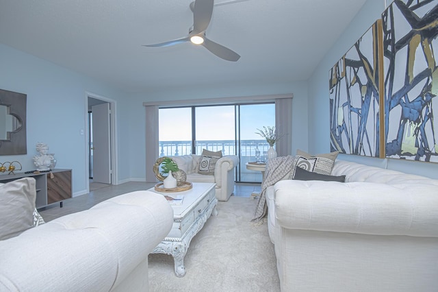 living area featuring baseboards and ceiling fan