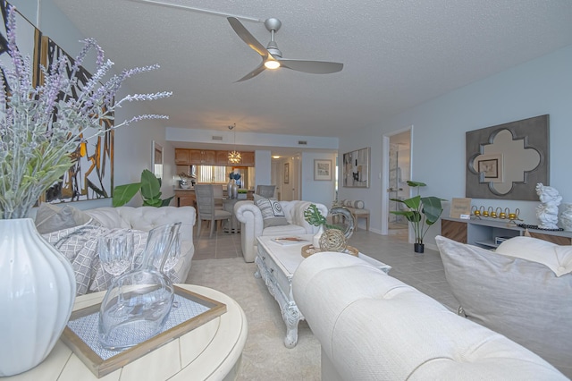 living room with light tile patterned floors, a textured ceiling, and ceiling fan