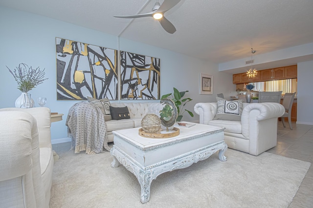 living area featuring light tile patterned floors, a textured ceiling, and ceiling fan