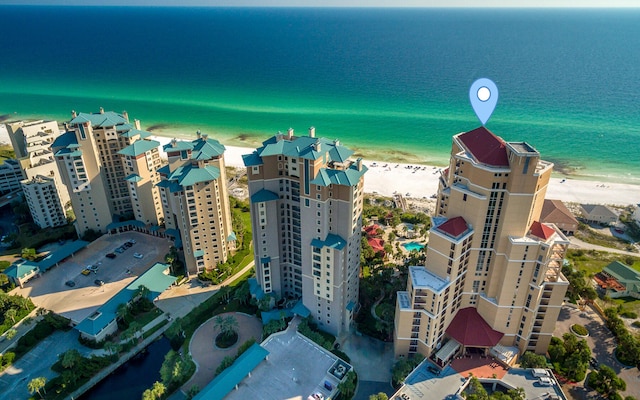 birds eye view of property with a water view and a beach view