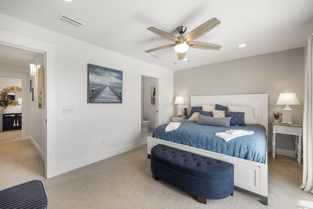 bedroom featuring ensuite bath, light colored carpet, and ceiling fan