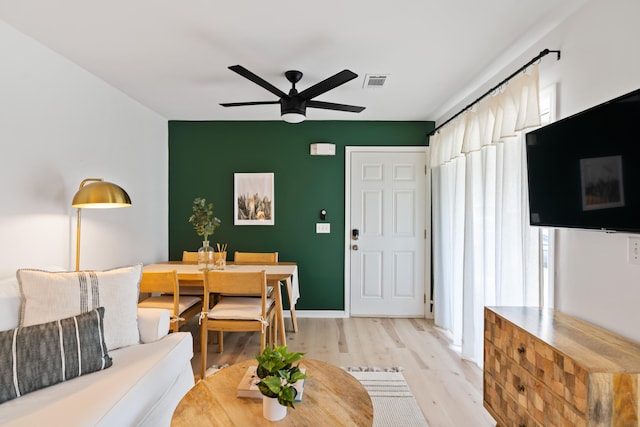 living room with ceiling fan, light wood-type flooring, and a wealth of natural light