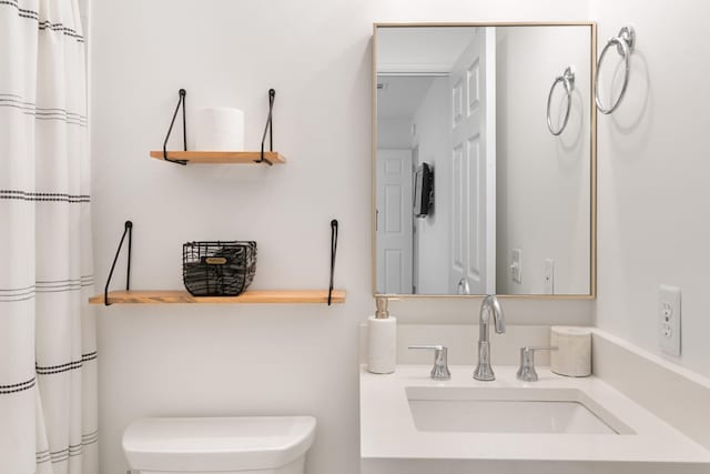 bathroom with curtained shower, vanity, and toilet