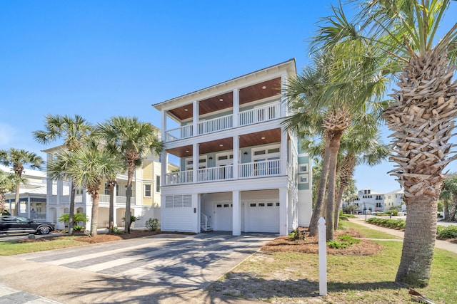 raised beach house featuring a garage and a balcony