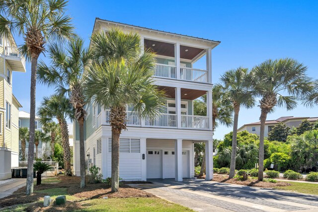 raised beach house featuring a balcony and a garage