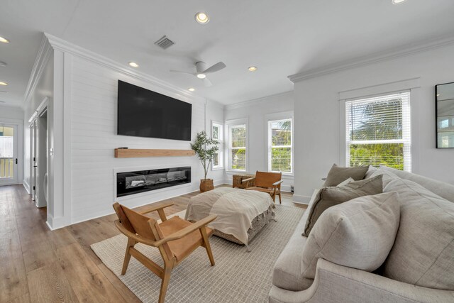 living room with ceiling fan, light hardwood / wood-style floors, and ornamental molding