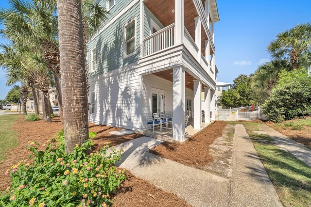 view of side of home with a patio, a balcony, and french doors