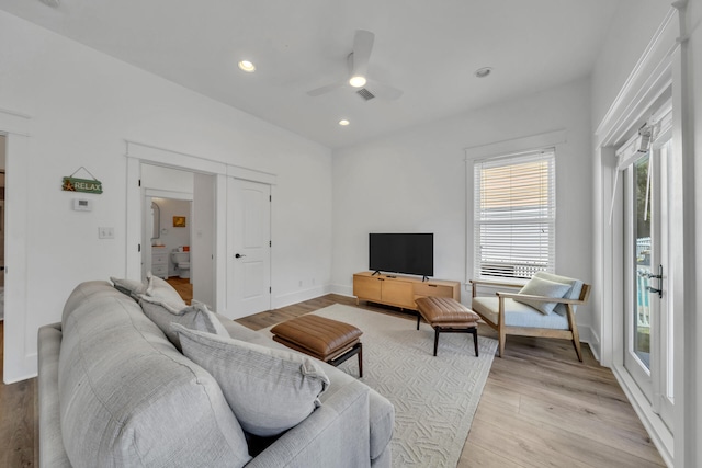 living room featuring ceiling fan and light hardwood / wood-style flooring