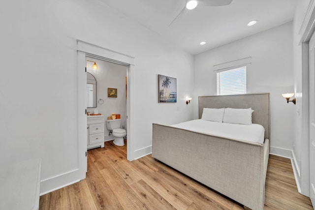 bedroom featuring light hardwood / wood-style flooring, ceiling fan, and ensuite bathroom