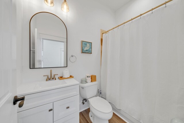 bathroom featuring toilet, hardwood / wood-style flooring, and vanity