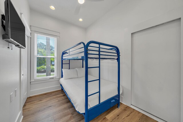 bedroom featuring hardwood / wood-style floors, multiple windows, and ceiling fan