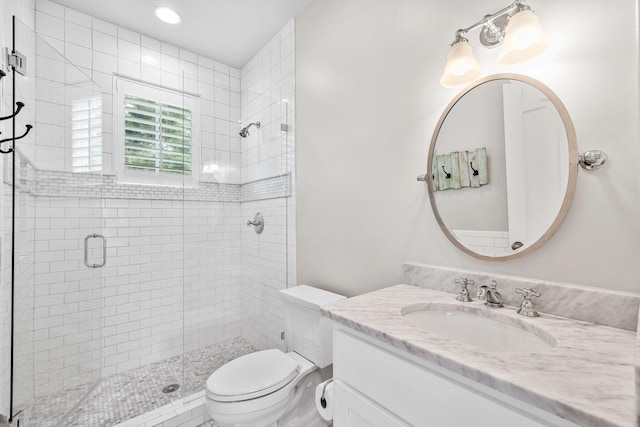 bathroom featuring an enclosed shower, toilet, and vanity