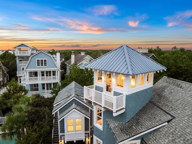 back house at dusk with a balcony