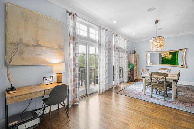 dining area featuring crown molding, a chandelier, and hardwood / wood-style floors