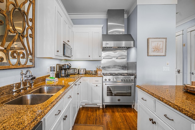 kitchen featuring appliances with stainless steel finishes, white cabinetry, sink, dark hardwood / wood-style floors, and wall chimney exhaust hood