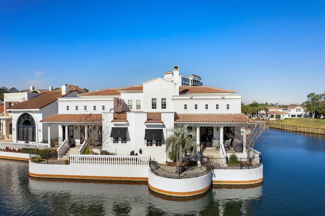 rear view of property featuring a patio and a water view