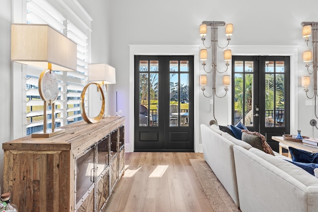 foyer featuring french doors, light wood-type flooring, and plenty of natural light