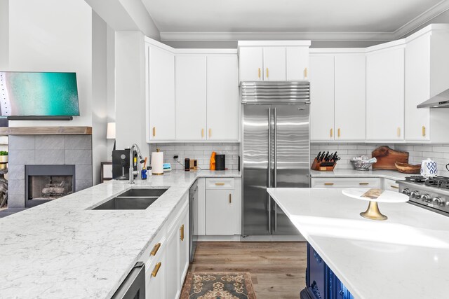 kitchen with light stone counters, white cabinets, appliances with stainless steel finishes, and sink