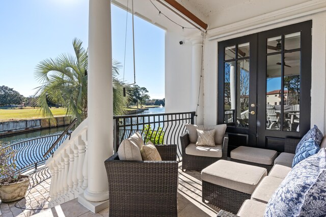 balcony featuring french doors, an outdoor hangout area, and a water view