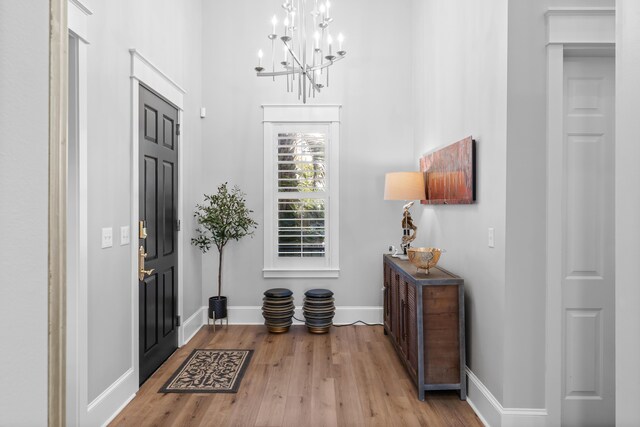 entryway featuring light wood-type flooring and a chandelier