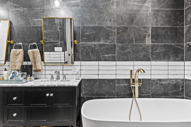 bathroom featuring a bathing tub, vanity, and tile walls