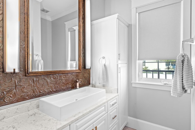 bathroom with ornamental molding and vanity