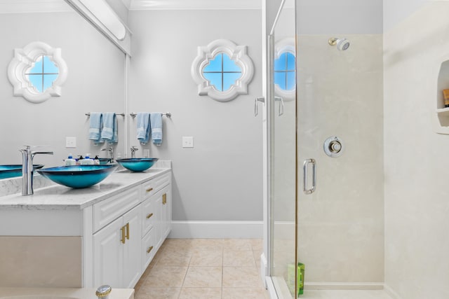 bathroom featuring vanity, a shower with shower door, tile patterned flooring, and crown molding