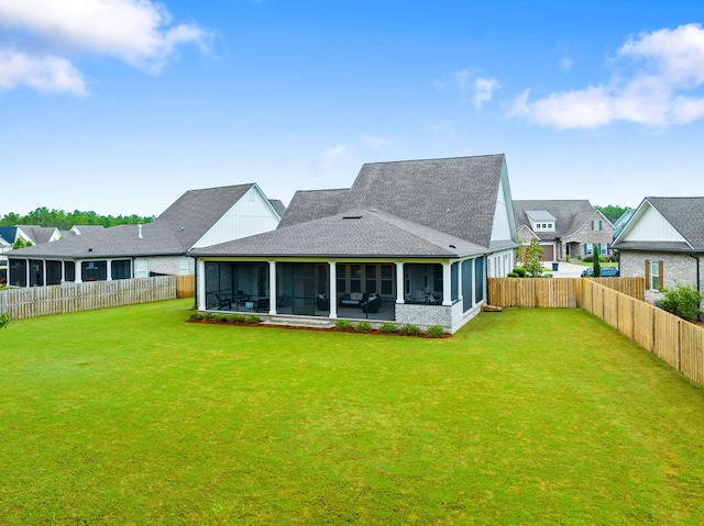 back of house featuring a lawn and a sunroom