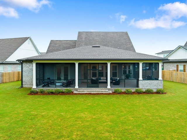 rear view of property with a lawn and a sunroom