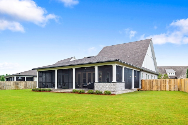 back of house featuring a lawn and a sunroom