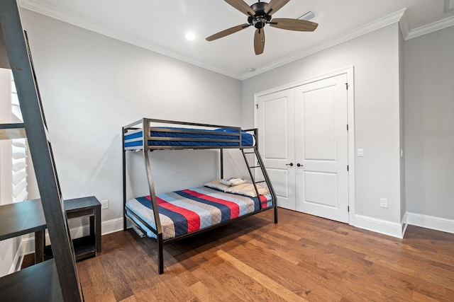 bedroom featuring a closet, wood-type flooring, ceiling fan, and crown molding