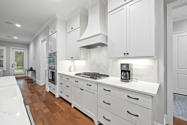 kitchen with premium range hood, white cabinetry, dark hardwood / wood-style flooring, and stainless steel appliances