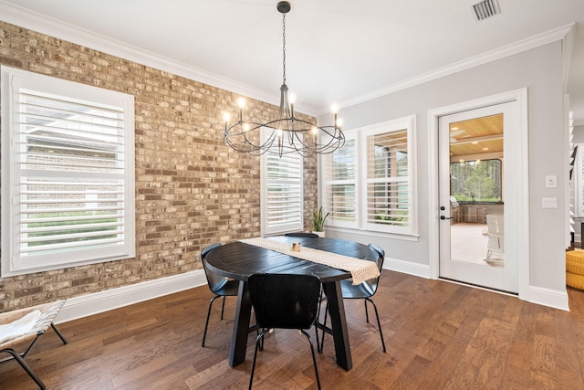 dining space featuring ornamental molding, brick wall, plenty of natural light, and dark hardwood / wood-style flooring