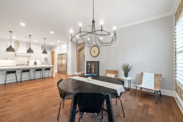 dining area with light wood-type flooring, crown molding, and a chandelier