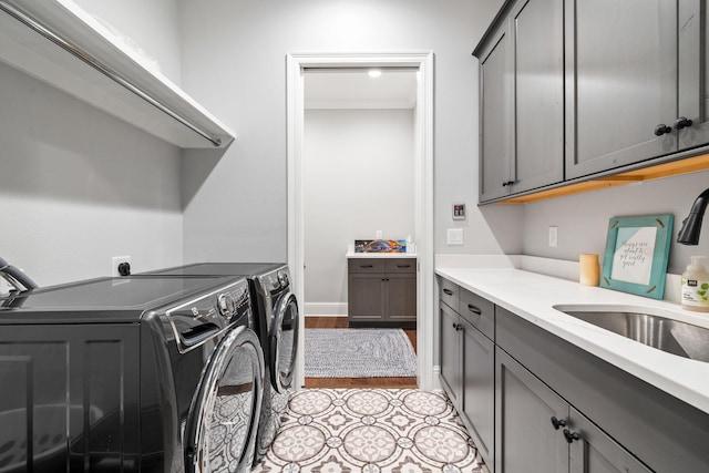 washroom with cabinets, sink, washing machine and clothes dryer, and light tile patterned flooring