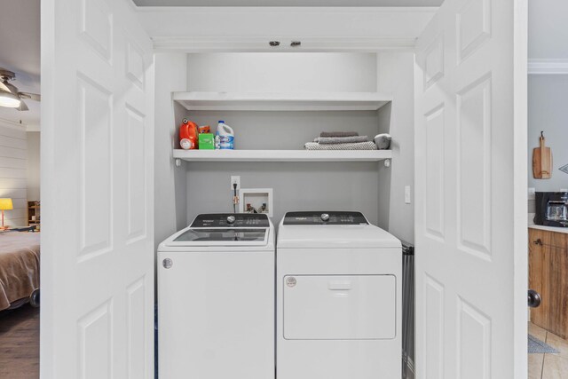 clothes washing area featuring light hardwood / wood-style flooring and washing machine and dryer