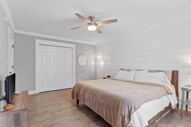 bedroom with a closet, ceiling fan, hardwood / wood-style flooring, and ornamental molding