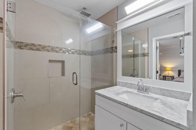 bathroom with a shower with door and vanity